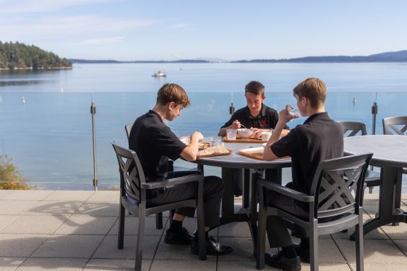 Three boys enjoying lunch outside on the oceanfront patio