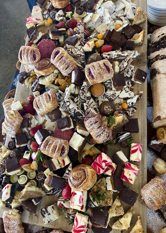 Pastries and chocolate desserts piled high on a long table